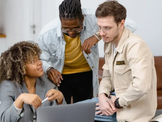 Image capturing MLM developers in a discussion, showcasing collaboration and teamwork in software development.